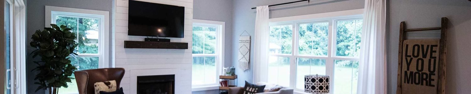 Great room addition in the farmhouse style, showcasing a high vaulted ceiling with white planking and a fireplace wall featuring shiplap and an integrated mantel.