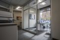 Designing for Profit: The Role of Commercial Architecture in Business Success, bright grey office with windows and grey carpet and grey chairs