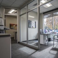 Designing for Profit: The Role of Commercial Architecture in Business Success, bright grey office with windows and grey carpet and grey chairs