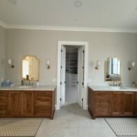 bathroom with two sinks and entrance to closet