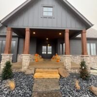 front door decorated with pumpkins and hay bales