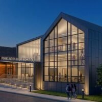 Night rendering of the Franklinton High School entrance with a two-story glass gable lit from within