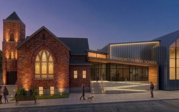 Rendering of Franklinton High School at dusk, showing the historic brick church building joined to the new glass and metal addition
