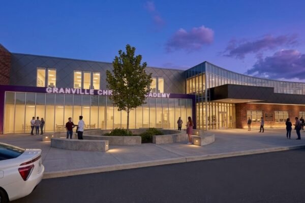 Rendering of the Granville Christian Academy entrance at dusk with lit glass storefront, tree-lined plaza and curved concrete seating